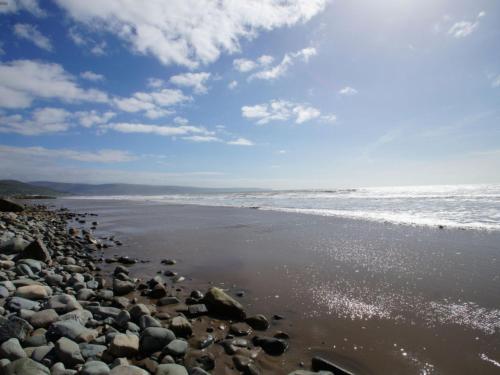 LlanddwyweにあるHoliday Home Idnusia by Interhomeの曇りの日の岩と海の浜
