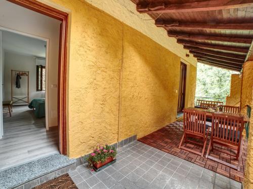 een kamer met een gele muur met een tafel en een stoel bij Apartment La Furnaseta by Interhome in Oleggio Castello