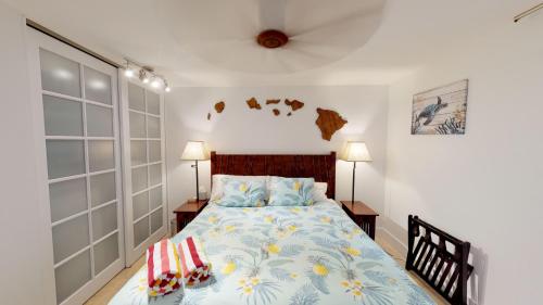 1 dormitorio con 1 cama con edredón azul en Stunning Sunsets and Oceanview's at Paki Maui en Lahaina