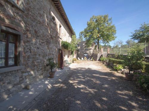 an alley in an old stone building with a tree at Holiday Home La Terrazza by Interhome in Radda in Chianti