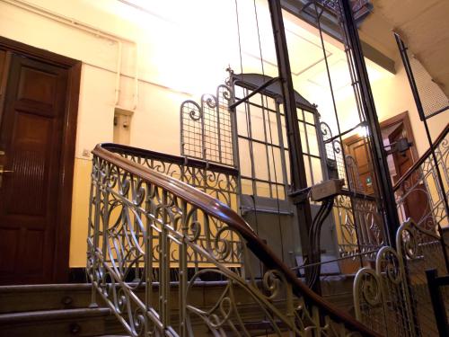 a staircase with a wrought iron railing next to a door at Trzy Kafki Private Rooms in Kraków