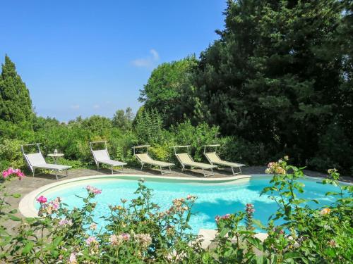 - une piscine avec des chaises longues et un bouquet dans l'établissement Villa La Casa Vivente by Interhome, à Livourne