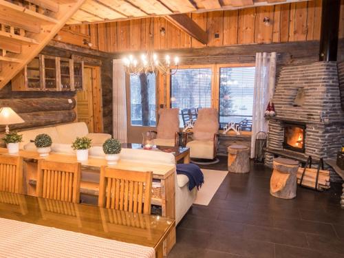 uma sala de estar com uma mesa e uma lareira em Holiday Home Villa aurora by Interhome em Säkkilänvaara