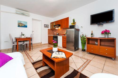 a living room with a table and a kitchen at Apartment & Rooms Graciela in Rovinj