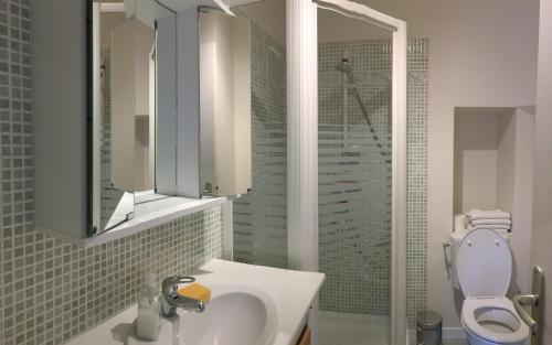 La salle de bains est pourvue d'un lavabo, de toilettes et d'un miroir. dans l'établissement La Maison des Matignon 2, à Granville
