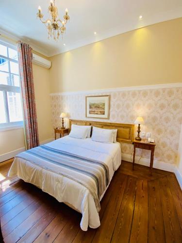 a bedroom with a large bed and a chandelier at Hotel Casablanca Imperial in Petrópolis