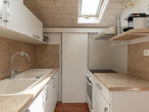 une petite cuisine avec des armoires blanches et un évier dans l'établissement Apartment Les Choupou by Interhome, à Arcachon