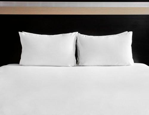 a white bed with a white comforter and pillows at Holiday Inn Bristol City Centre, an IHG Hotel in Bristol