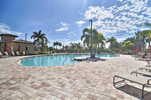a swimming pool in a resort with chairs and palm trees at River Strand Country Club Condo with Pool Access! in Bradenton