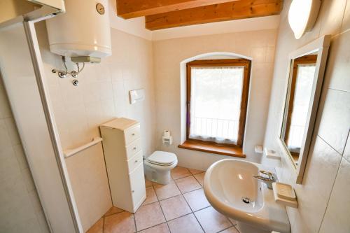 a bathroom with a sink and a toilet and a window at AGRITURISMO COLOMBARE TEBOI in Lazise