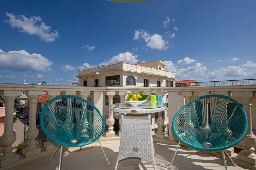 a patio with two chairs and a table on a balcony at Cozy Corner Analipsi Apartment in Zakynthos