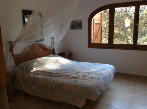 een slaapkamer met een bed en een raam bij Beautiful detached villa close to sandy beach, shops and restaurants in Begur