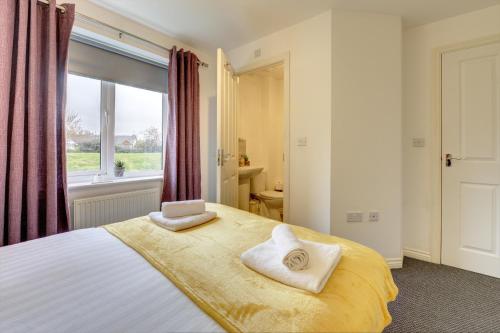 a bedroom with a bed with two towels on it at 2-BR Apartment, En-suite, Allocated Parking, next to Playground in Coventry