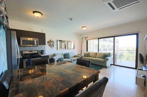 a kitchen and living room with a large table at Aruba Stop by The Stop Club in Palm-Eagle Beach
