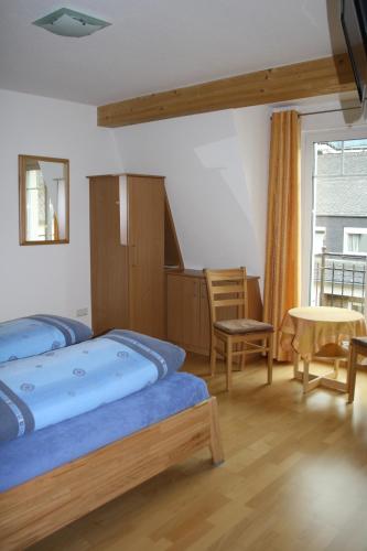 a bedroom with two beds and a table and a window at Weingut Goeres in Briedel