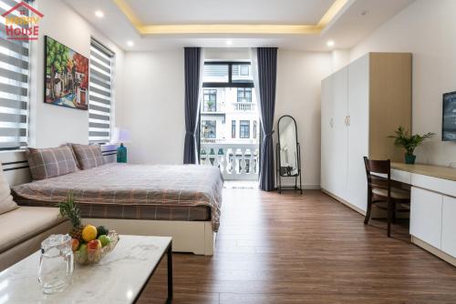a bedroom with a bed and a kitchen and a table at Merry House Imperia in Hai Phong
