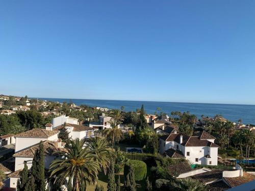 a view of a town with houses and the ocean at Vue mer exceptionnelle, El Rosario (Marbella). in Marbella