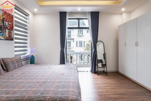 a bedroom with a bed and a large window at Merry House Imperia in Hai Phong