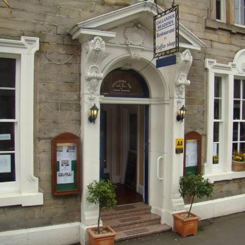 an entrance to a building with two potted plants in front at Callander Meadows in Callander