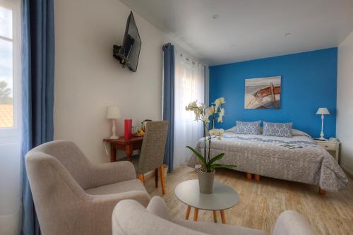 1 dormitorio con 1 cama, mesa y sillas en Hôtel Le Nautile en Saint-Trojan-les-Bains