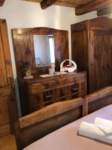 a bedroom with a wooden dresser and a mirror at CASA ANGELA Stayerat a SEGUSINO Valdobbiadene in Segusino
