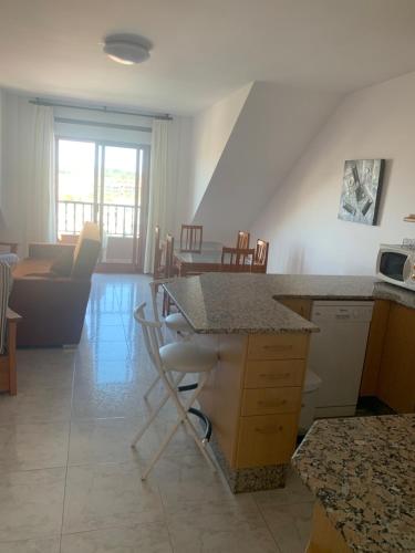 a kitchen and living room with a table and chairs at Apartamentos Corea in Portonovo