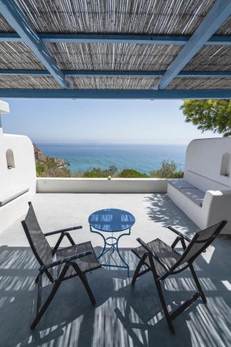 a patio with chairs and a table and a couch at Apollon Village Hotel in Anafi