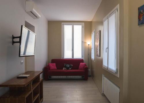 a living room with a red couch and a window at Corte del Tintor Apartments in Venice