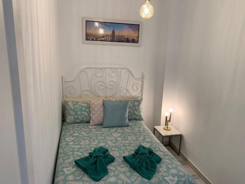 um pequeno quarto com uma cama com almofadas verdes em DREAM SMILE em Santa Cruz de Tenerife