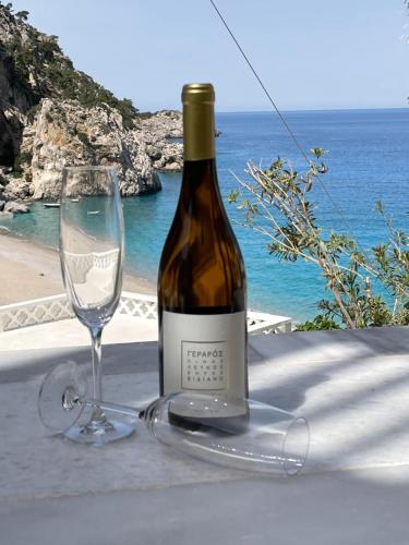 a bottle of wine and a glass on a table at The View Condo No2 'The Emmanuel' in Kyra Panagia