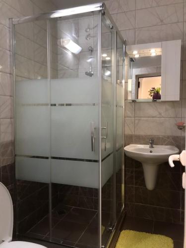 a bathroom with a glass shower and a sink at сем. Павлови in Obzor