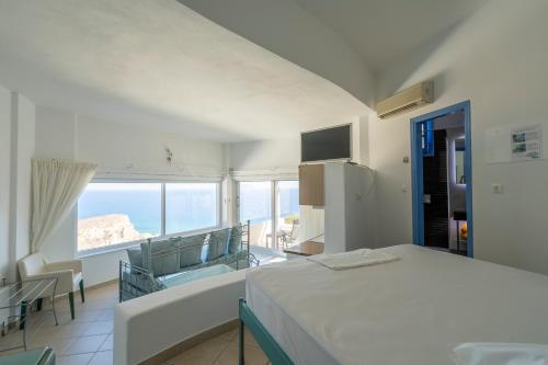 a bedroom with a bed and a view of the ocean at Apollon Village Hotel in Anafi
