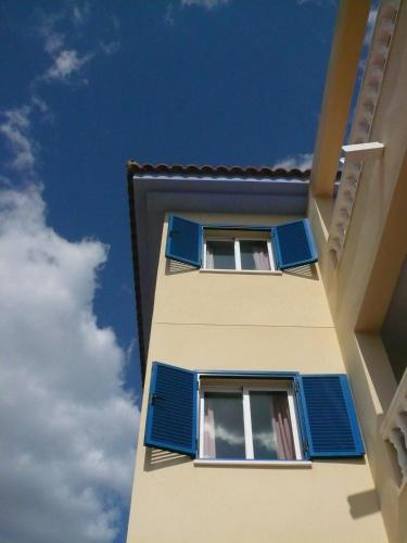 two windows with blue shutters on a building at Hotel Mayarí Boutique Hotel in Calabardina