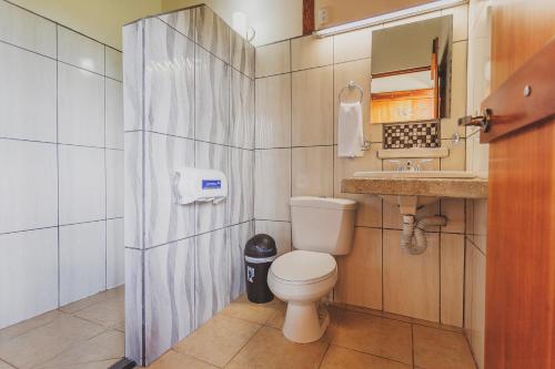 a small bathroom with a toilet and a sink at Hotel La Hacienda in Quesada