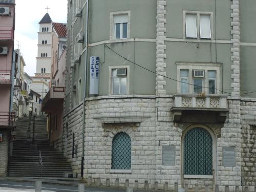an old stone building with stairs on a city street at Apartments Popov in Crikvenica