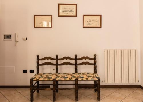 a wooden bench sitting in front of a white wall at Agriturismo Stovali Da Lustrinu in Protte
