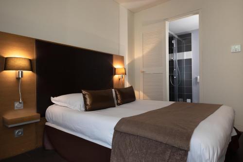 カステルノーダリにあるHotel Restaurant du Centre et du Lauragaisのベッドルーム1室(大型ベッド1台、黒いヘッドボード付)