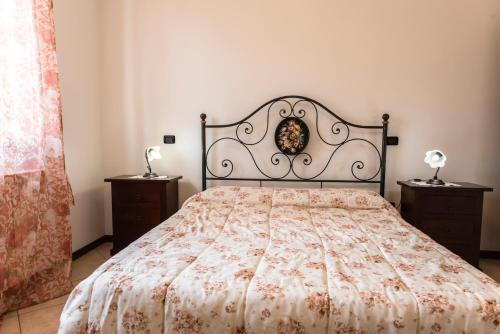 a bed in a bedroom with two night stands and two lamps at Agriturismo Stovali Da Lustrinu in Protte