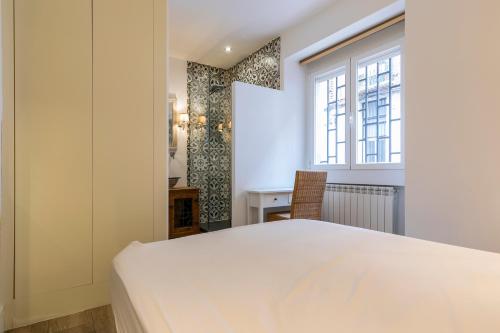HOMEABOUT DIEGO DE LEÓN Apartment I في مدريد: غرفة نوم بسرير ابيض كبير ونافذة