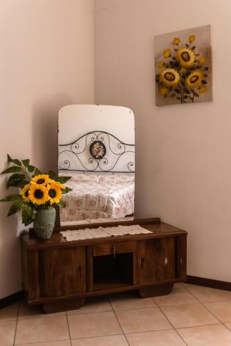 a bedroom with a bed and a mirror on a table at Agriturismo Stovali Da Lustrinu in Protte