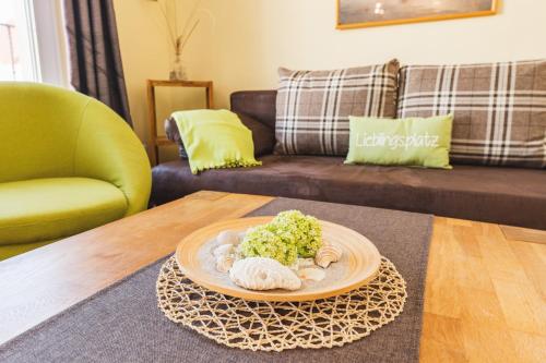 a living room with a table with a plate of food at Skerra Apartments "am Fitness-Studio" in Fehmarn