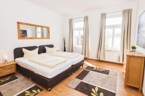 a living room with a bed and two windows at Skerra Apartments "am Fitness-Studio" in Fehmarn