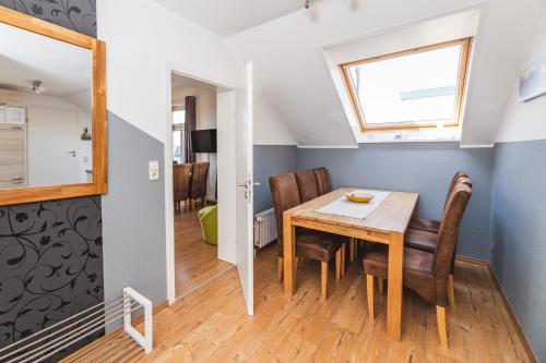 a kitchen and dining room with a table and chairs at Skerra Apartments "am Fitness-Studio" in Fehmarn