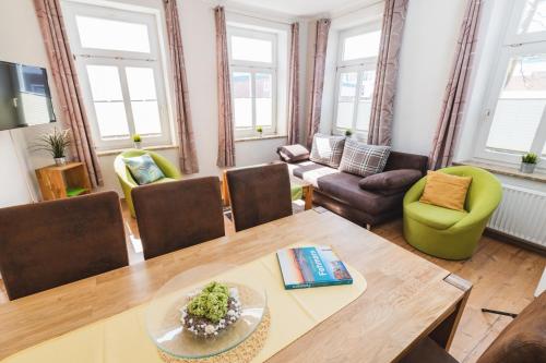 a living room with a table and chairs at Skerra Apartments "am Fitness-Studio" in Fehmarn
