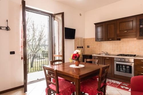 a kitchen with a dining room table and a window at Agriturismo Stovali Da Lustrinu in Protte