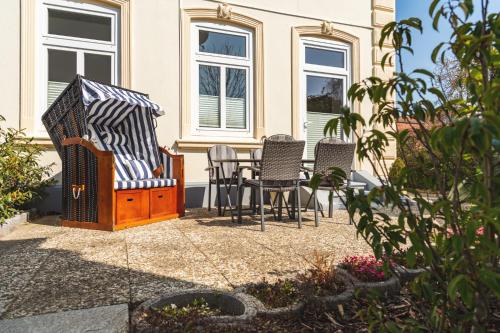 a patio with chairs and a table in front of a house at Skerra Apartments "am Fitness-Studio" in Fehmarn