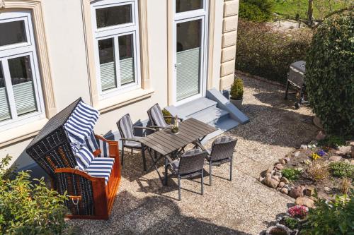 a patio with chairs and a table and a table and chairs at Skerra Apartments "am Fitness-Studio" in Fehmarn