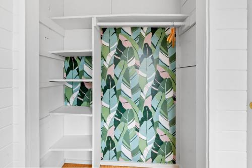 a walk in closet with a green and white wallpaper at Cayuga Street Sunshine Retreat in Ocean Bay Park