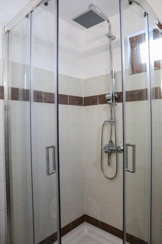 a shower with a glass door in a bathroom at Heliophilia Lindos in Lindos