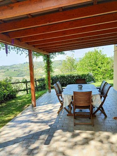 a patio with a table and chairs under a pergola at Villa Luna in San Floriano del Cóllio
